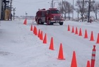 Firetruck driving through orange traffic cones